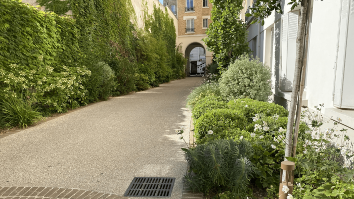 Grande allée en béton d'un jardin en copropriété conçu par Jean-Christophe Prévost