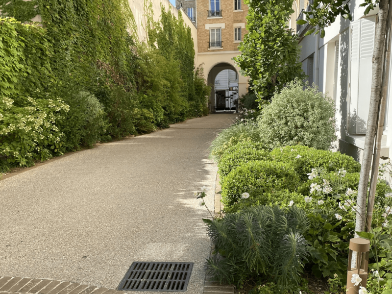 Grande allée en béton d'un jardin en copropriété conçu par Jean-Christophe Prévost