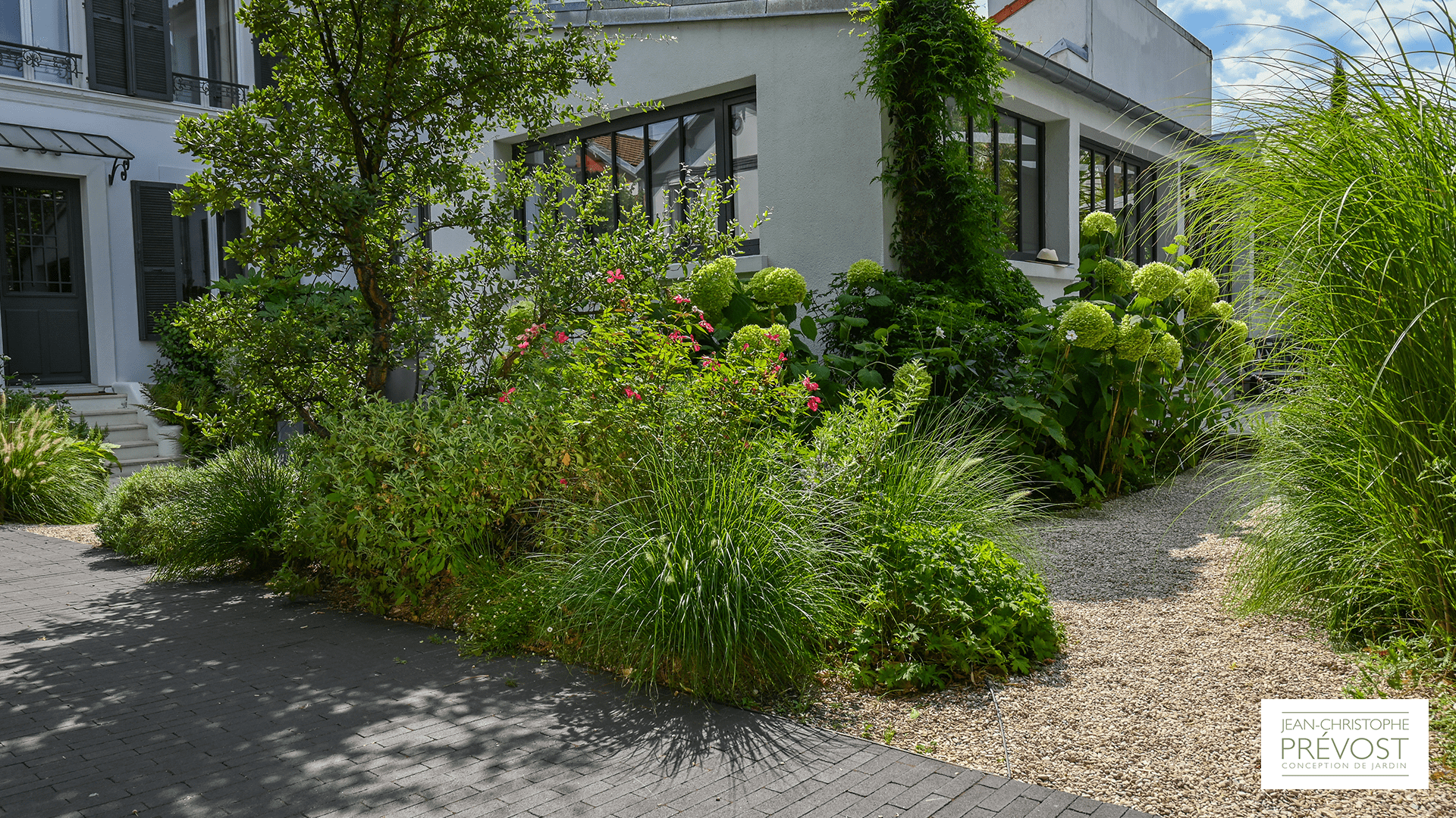 Devant d'un jardin avec des plantes, fleurs et buissons